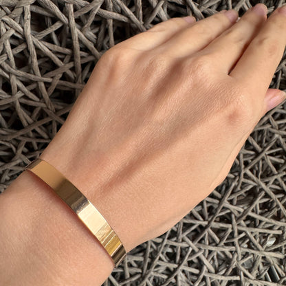 Thread wrap bracelet worn on the wrist with a slim gold-tone open band
