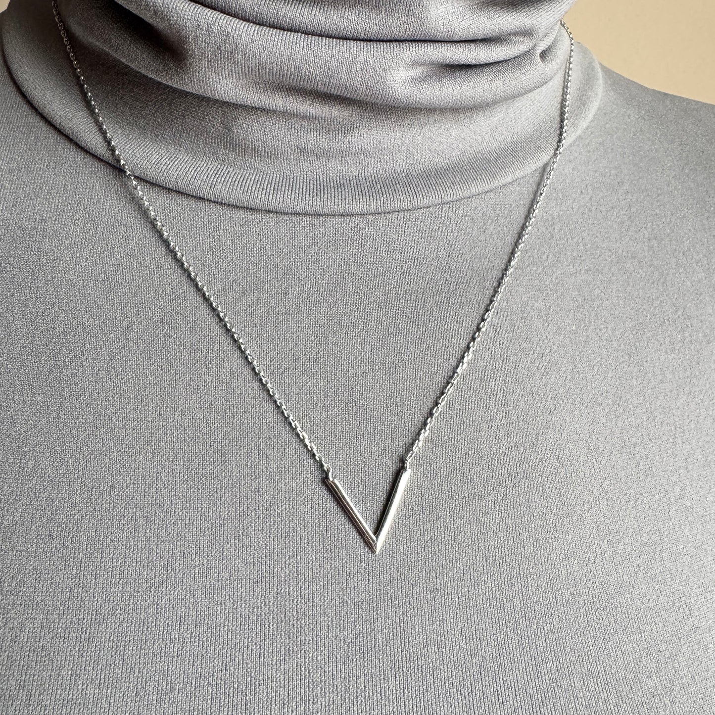Minimalist geometric necklace IRL worn on the neck with a sleek V-shaped pendant