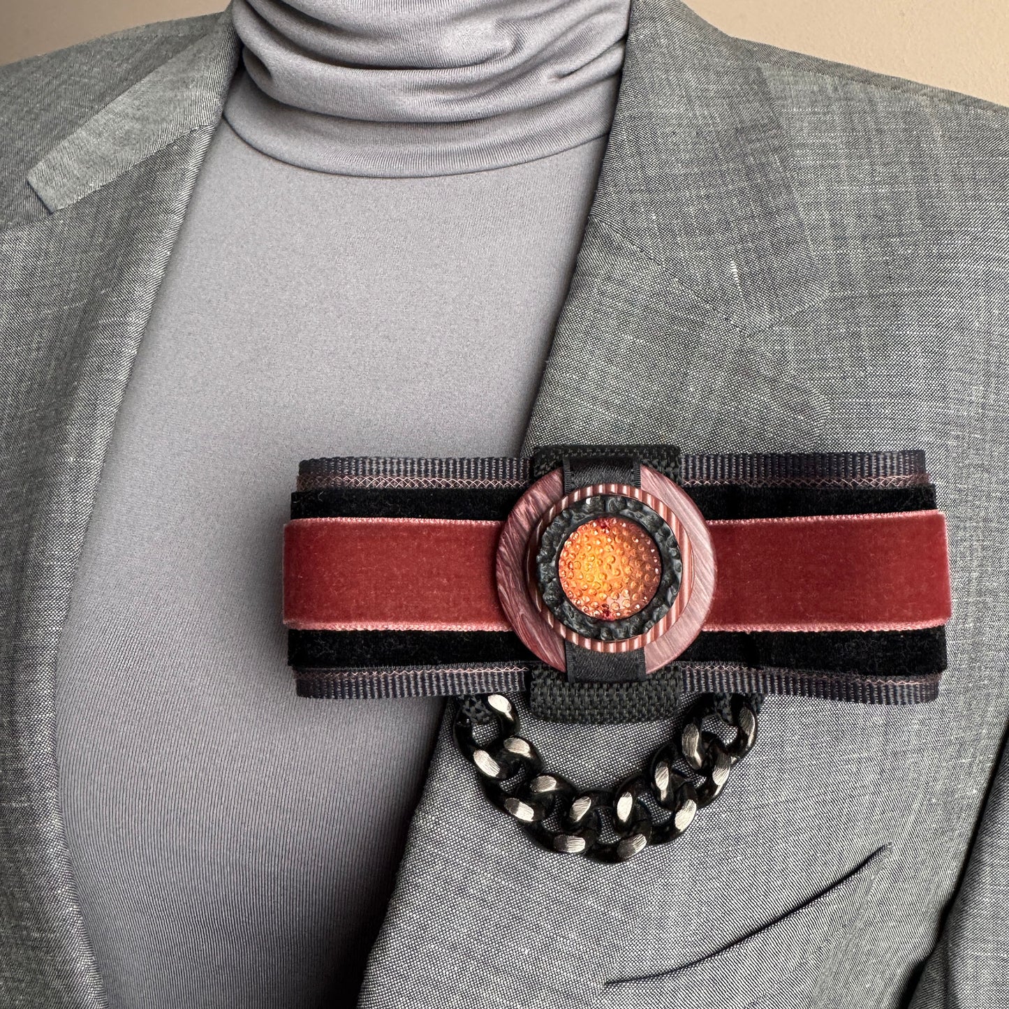 Velvet brooch Sonata worn on a blazer with ribbon layers and a bold chain detail