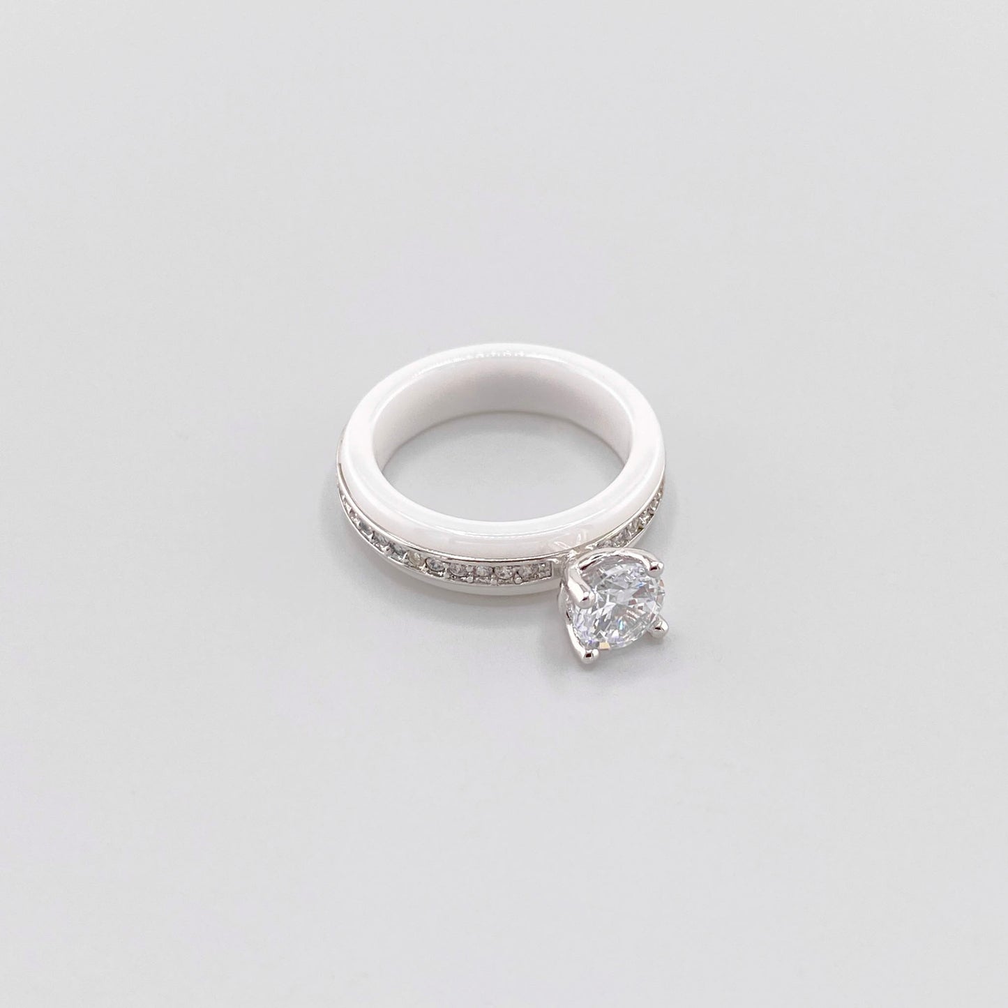 White ceramic ring by Luxury Avenue shown at an angle with a round crystal and silver-tone detailing