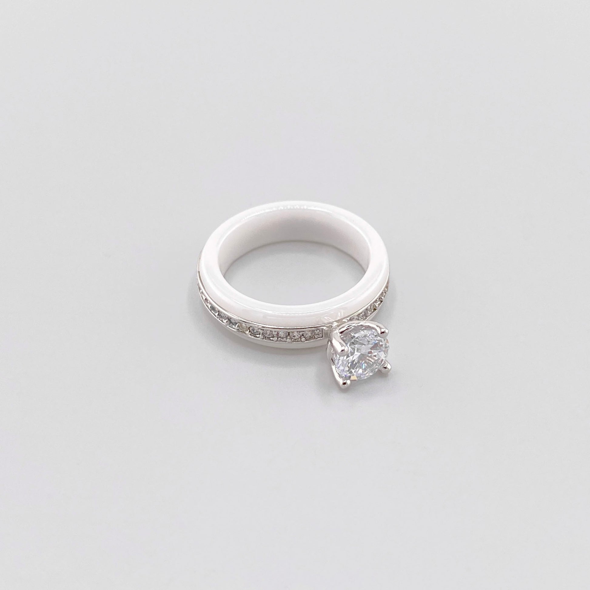 White ceramic ring by Luxury Avenue shown at an angle with a round crystal and silver-tone detailing
