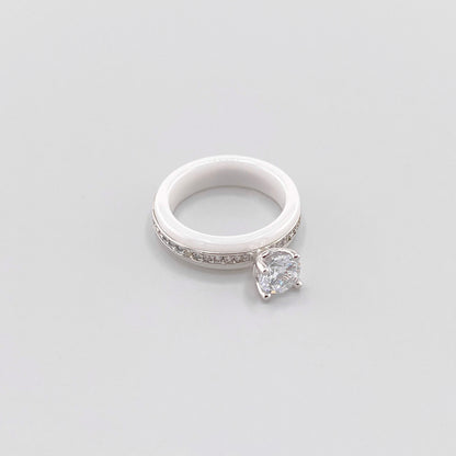 White ceramic ring by Luxury Avenue shown at an angle with a round crystal and silver-tone detailing