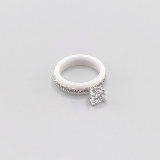 White ceramic ring by Luxury Avenue shown at an angle with a round crystal and silver-tone detailing