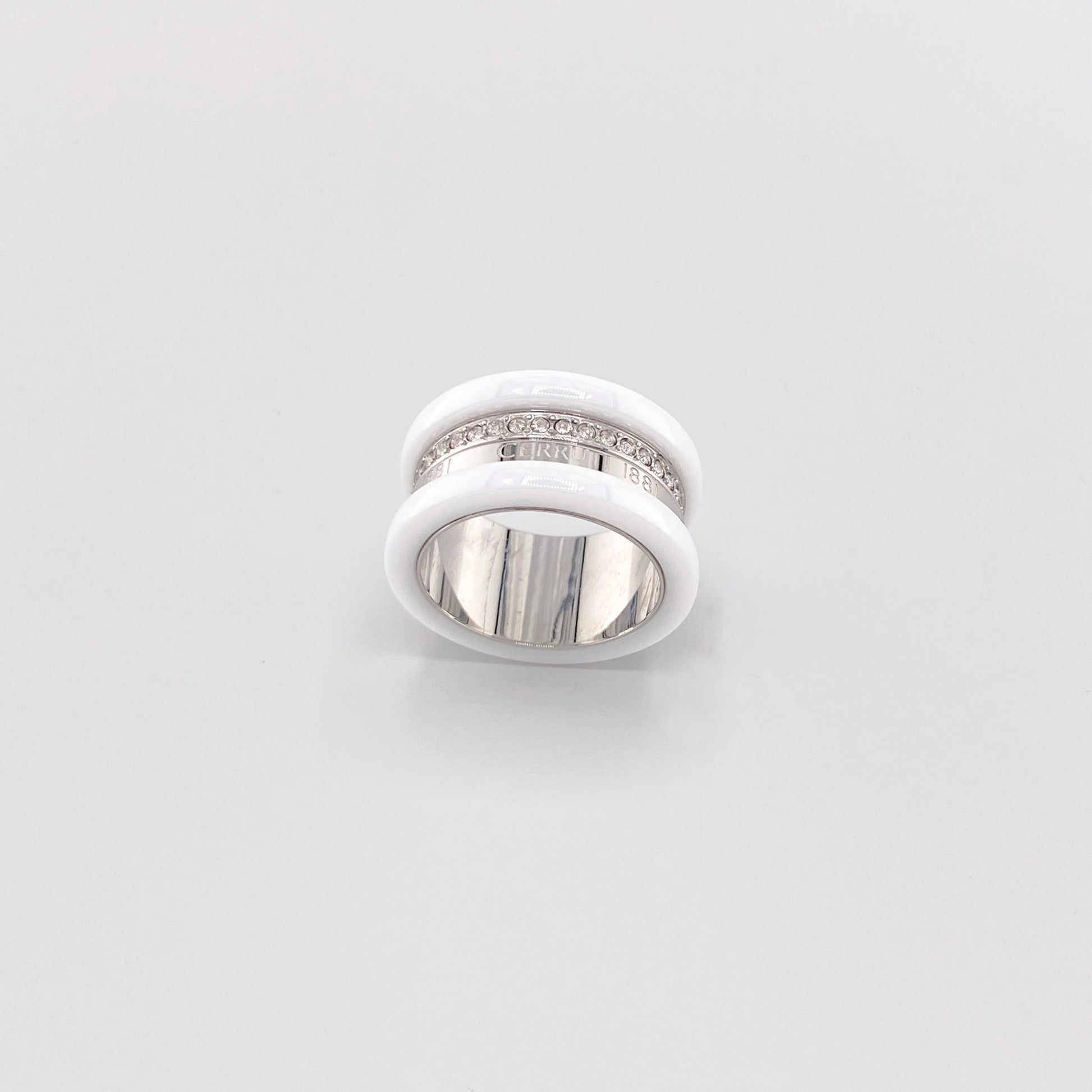 White ceramic ring by Cerruti 1881 with a wide band, silver-tone detailing, and engraved logo