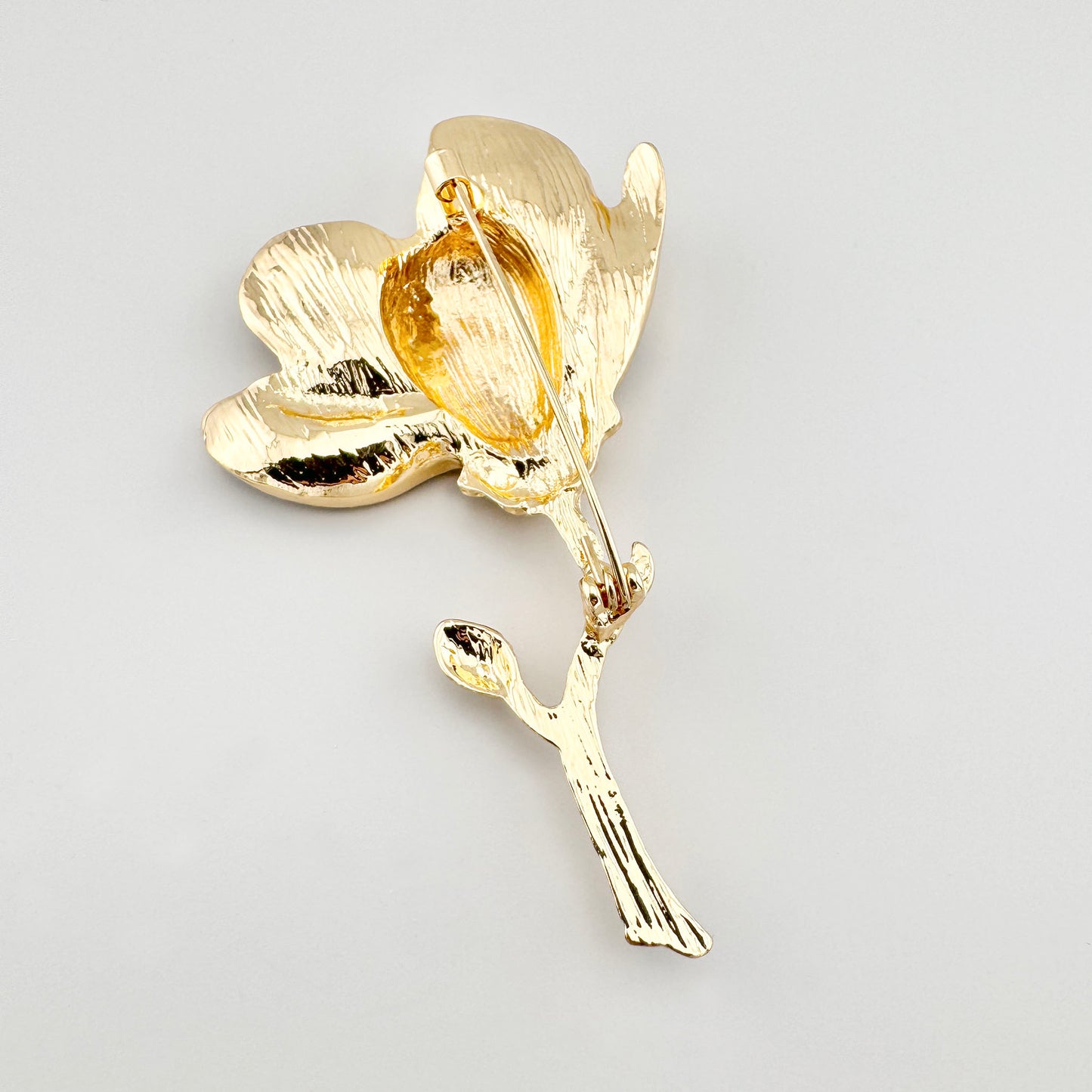 Weiße Blumenbrosche Sonata mit goldfarbener Rückseite und floraler Form