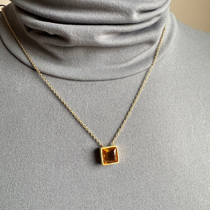 Yellow quartz pendant necklace worn at the neckline on a delicate chain