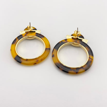 Деталь геометрических серьг IRL из акрила, тонкий контраст металла и цветного пластика