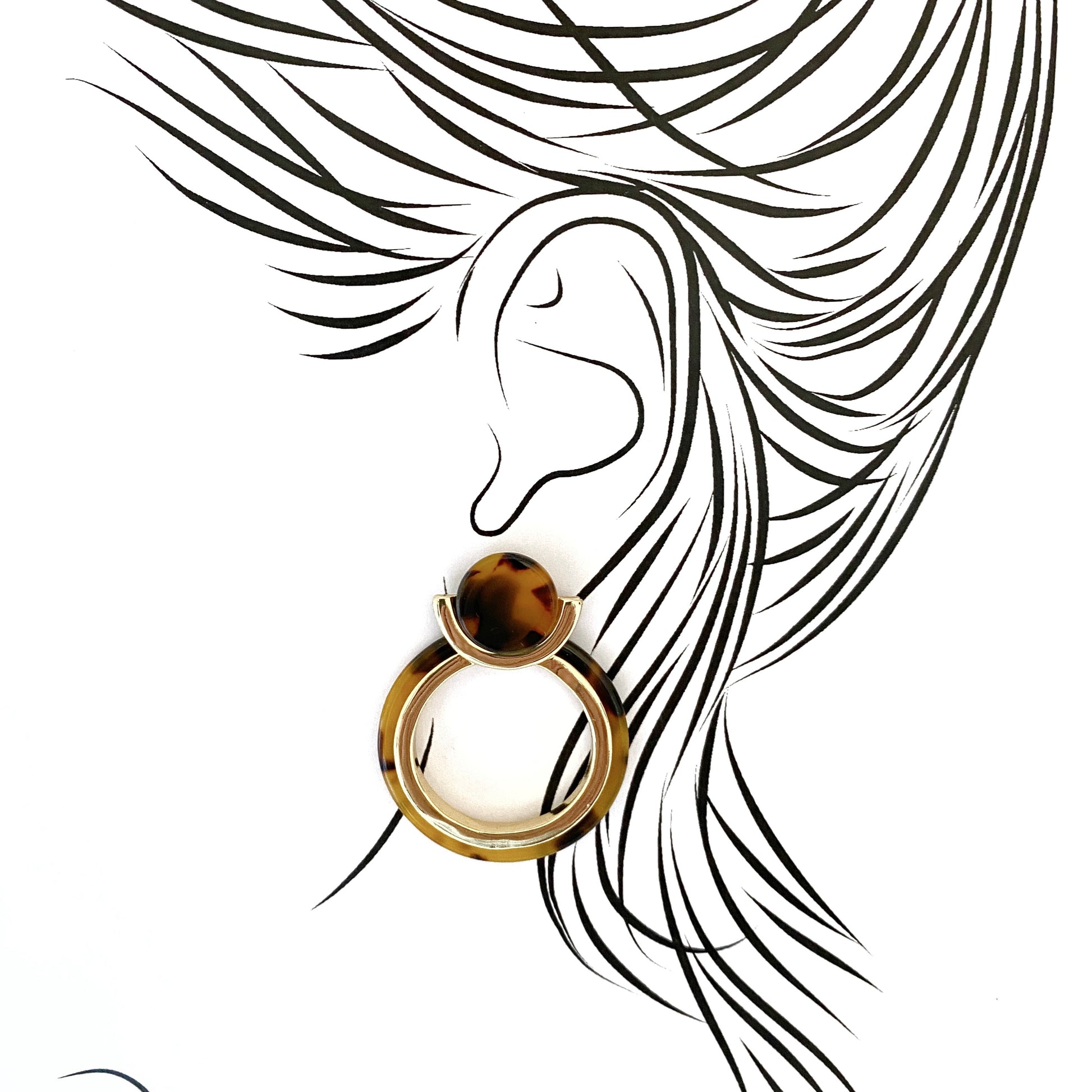 Geometric hanging earrings IRL worn on ear, clean circular composition