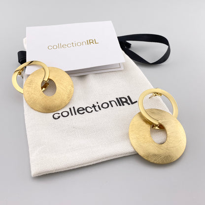 Boucles rondes IRL dorées avec pochette de marque en fond clair