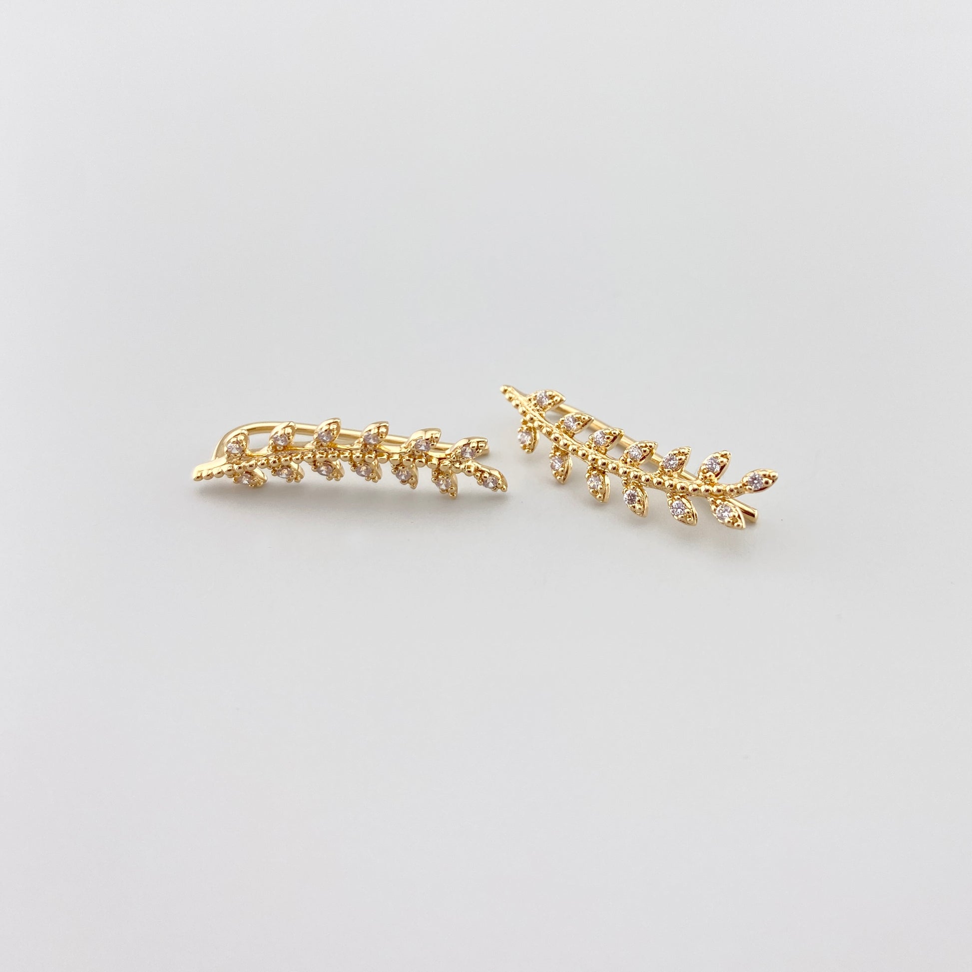 Pozłacane nausznice IRL z cyrkoniami w kształcie delikatnej gałązki, subtelny błysk