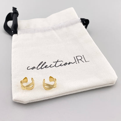 Aros tipo clip dorados con diseño tallado y bolsa de marca