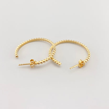Aros dorados calados con textura en primer plano