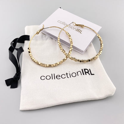 Aros dorados con detalles facetados y bolsa de marca IRL