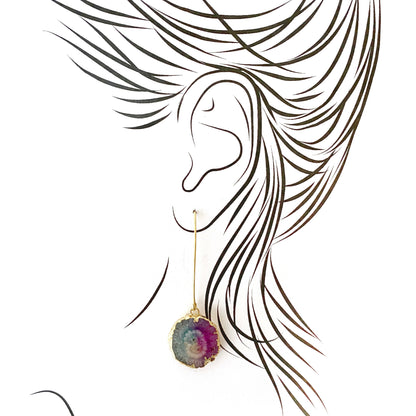 Artistic illustration of long gold-plated earrings with raw tourmaline stones
