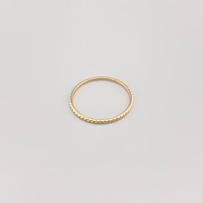Minimalistyczny pierścionek IRL z pozłacaną powierzchnią na białym tle