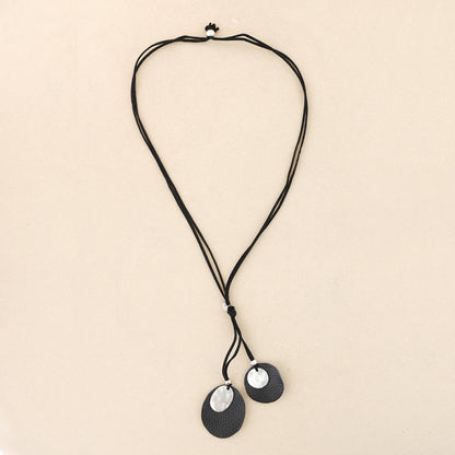 Collar negro boho con colgantes orgánicos de cuero y piezas plateadas