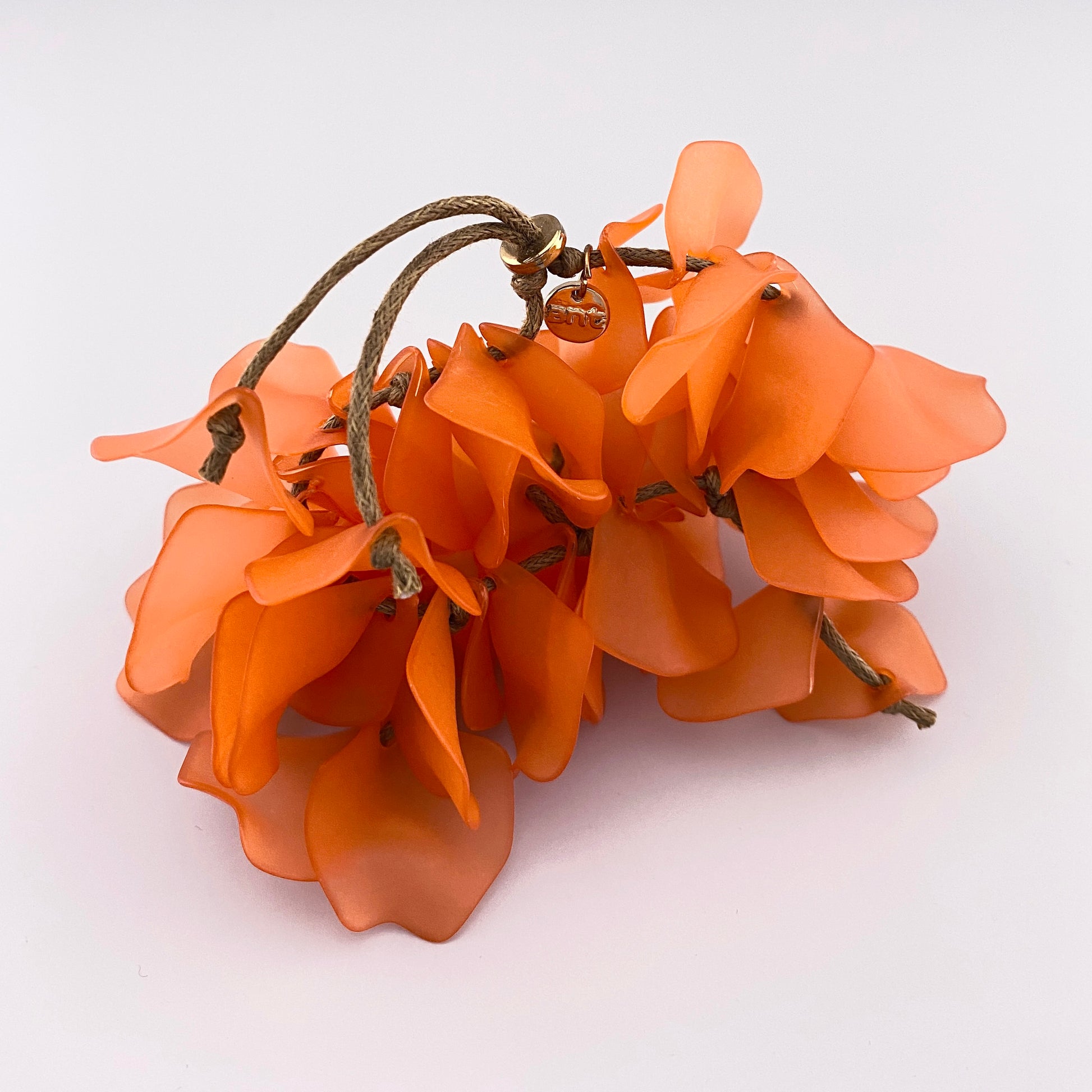 Pulsera con pétalos de flor en coral intenso y banda elástica