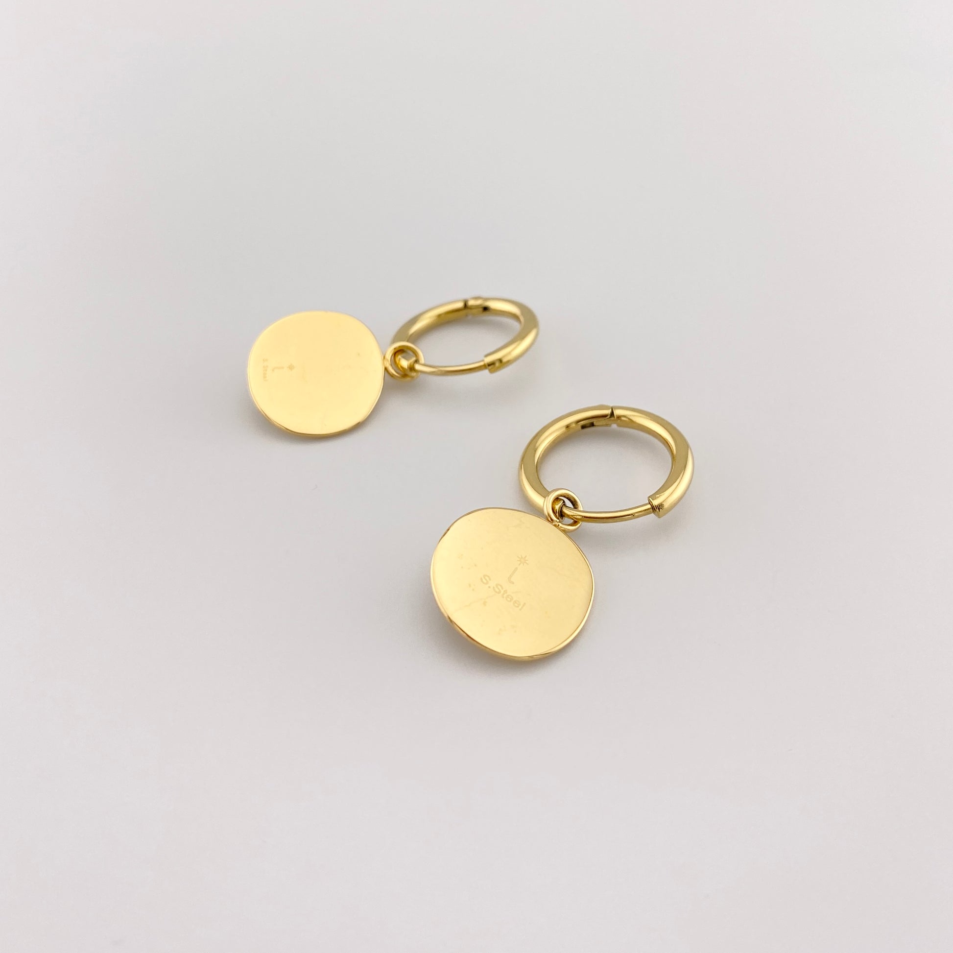 Aros IRL con medallón estrella y circonita, acabado espejo y gesto elegante