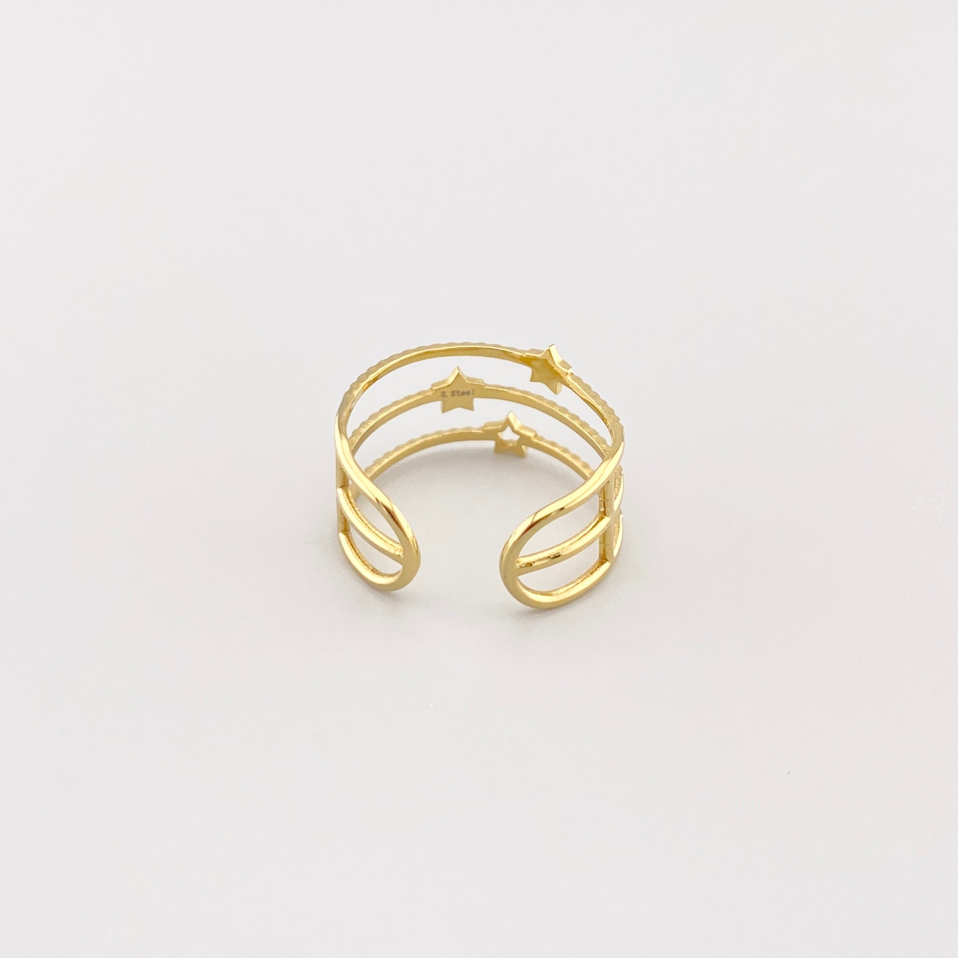 Anillo triple IRL dorado con textura y estrellas visto de arriba