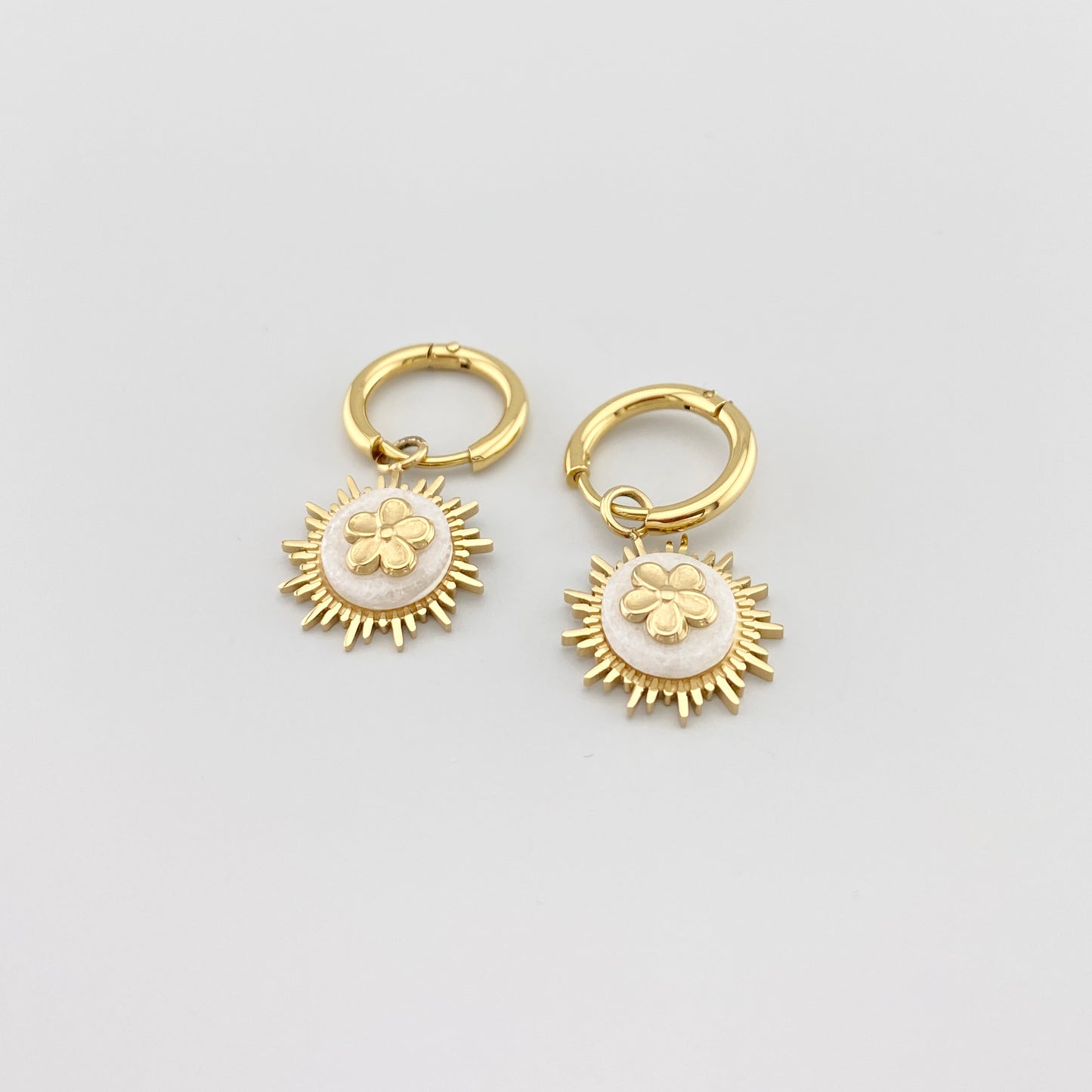 Kolczyki koła IRL z białym agatem i złoceniem, gładkie obręcze i kwiatowy dekor w centrum