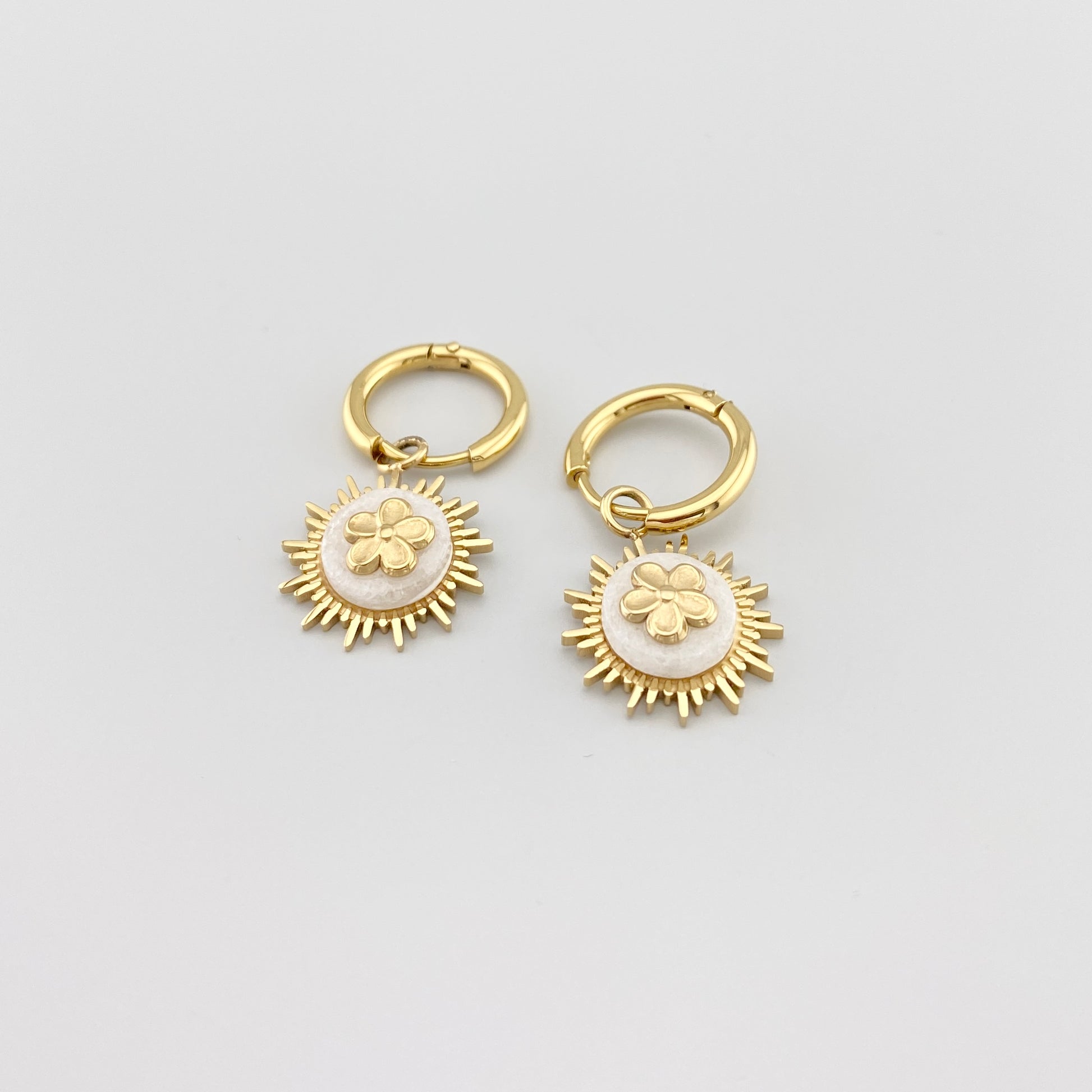 Kolczyki koła IRL z białym agatem i złoceniem, gładkie obręcze i kwiatowy dekor w centrum