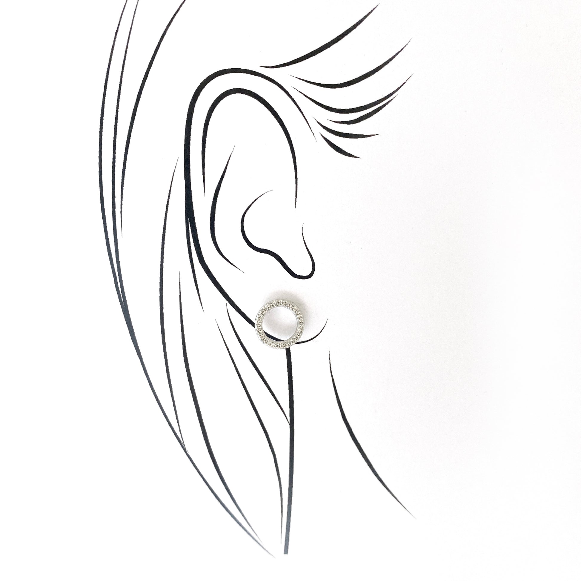 Silver hoop earrings with zirconia accents worn close to the ear